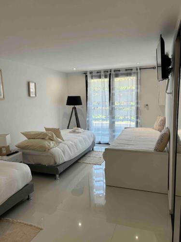 une chambre avec deux lits et une fenêtre dans l'établissement Cannes Centre Grande Villa piscine chauffée, à Cannes