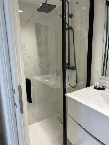 une salle de bain blanche avec une douche et un lavabo dans l'établissement Cannes Centre Grande Villa piscine chauffée, à Cannes