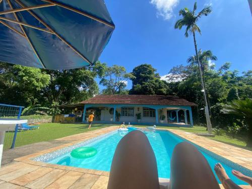 a person laying on a chair in front of a swimming pool at Rancho FILADÉLFIA in Guapimirim