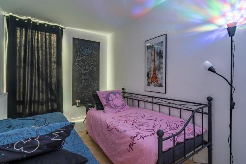 - une chambre avec un lit rose et une lampe dans l'établissement Family apartment facing lakes - Paris & Disneyland, à Lognes