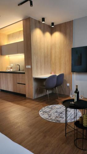 a living room with a table and a kitchen at Apartmani Dobrinja - Free parking- Rent a car in Sarajevo