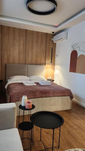 a bedroom with a bed with two tables and a couch at Apartmani Dobrinja - Free parking- Rent a car in Sarajevo