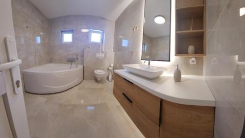 a bathroom with a tub and a sink and a toilet at Apartmani Dobrinja - Free parking- Rent a car in Sarajevo