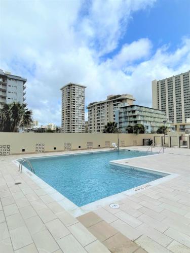 a swimming pool with buildings in the background at Island Vacations in Honolulu