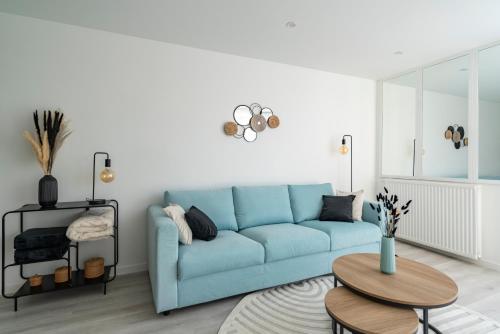 un salon avec un canapé bleu et une table dans l'établissement Family apartment facing lakes - Paris & Disneyland, à Lognes