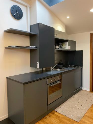 una cucina con un lavandino e un orologio a parete di Le Mura Minicase int 4 a Castelfranco Veneto