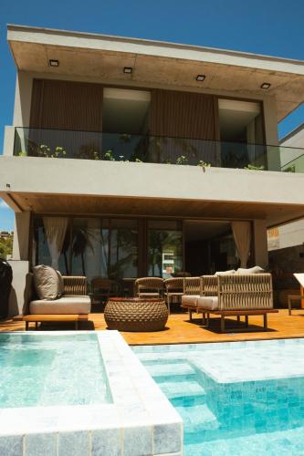 a house with a swimming pool next to a building at Casa Believe Milagres in Passo de Camarajibe