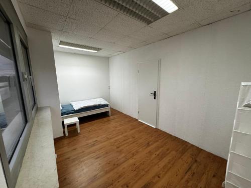 an empty room with a bed and a door at D1 Frankfurt 230m2 - 7 Einzelzimmer mit 2 Parkplätzen in Dreieich