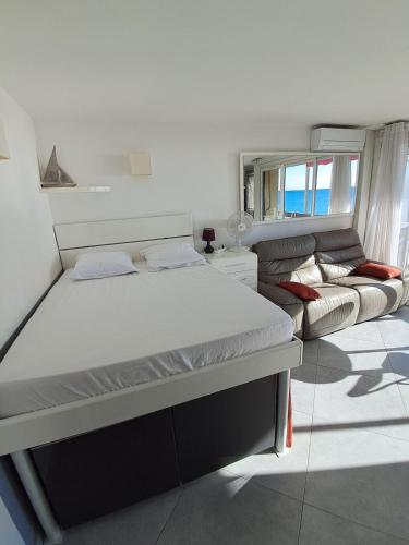 une chambre avec un lit et un canapé dans l'établissement studio face à la mer, à Sainte-Maxime