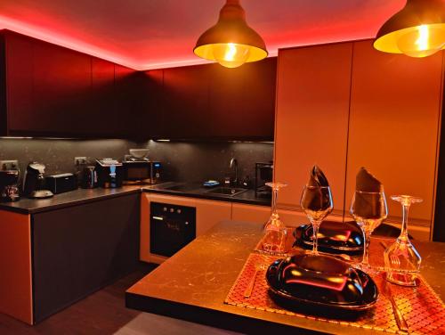 a kitchen with a table with wine glasses on it at Appartement LOVE ROOM LUXE in Bavay