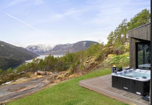 a house on a hill with a hot tub at Sogndal Fjordpanorama - Studio Cabins With View in Sogndal