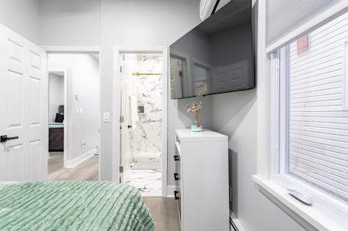 新罗谢尔Modern Escape 3BR Apt with Parking的一间带床和窗户的白色卧室