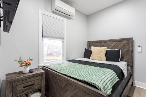 a bedroom with a large wooden bed with a window at Modern Escape 3BR Apt with Parking in New Rochelle