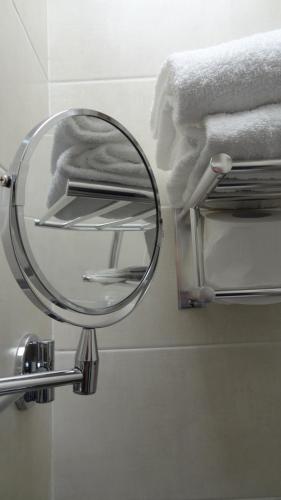 a mirror on a wall in a bathroom with towels at Hotel Piacenza in Milan