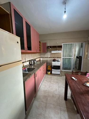 a kitchen with pink cabinets and a white refrigerator at Rincón familiar in Formosa
