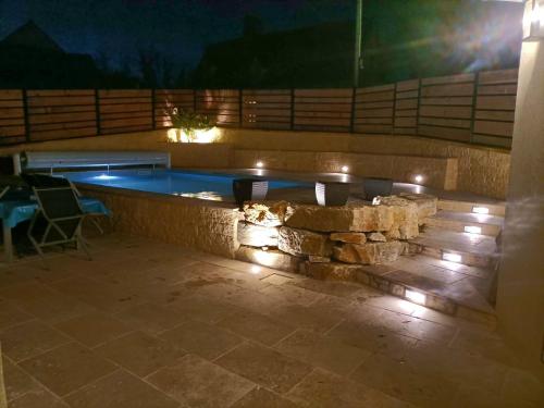 - une piscine avec des lumières sur le patio la nuit dans l'établissement Gîte Jeandrée Vitrac Perigord, à Vitrac