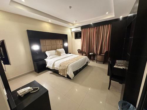 a hotel room with a bed and a desk at منازل الحمراء السكنية للشقق المخدومة "إقتصادي" in Buraydah