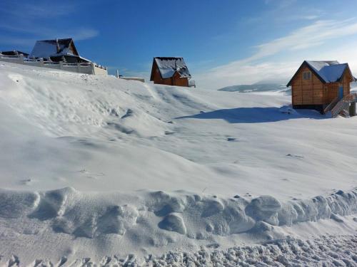 a snow covered hill with houses on top of it at Zlatibor Sky Inn in Zlatibor
