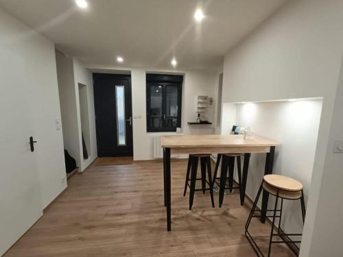une cuisine avec une table et des tabourets dans une pièce dans l'établissement Maison cosy à Touillon, à Touillon