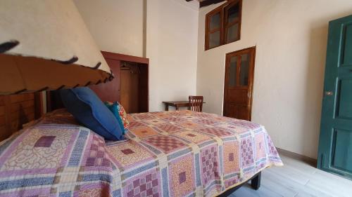 a bedroom with a bed with a quilt on it at Hotel Sautto in San Miguel de Allende