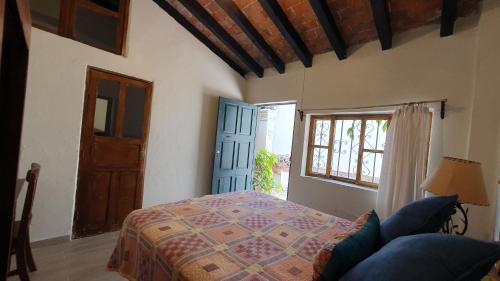 a bedroom with a bed and a door and a window at Hotel Sautto in San Miguel de Allende
