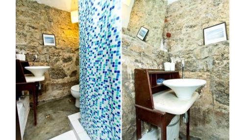 a stone bathroom with two sinks and two toilets at Casa da Carmen e do Fernando in Rio de Janeiro