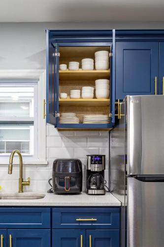 a kitchen with blue cabinets and a counter top with dishes at Comfort Meets Style 3BR Plus Parking in New Rochelle
