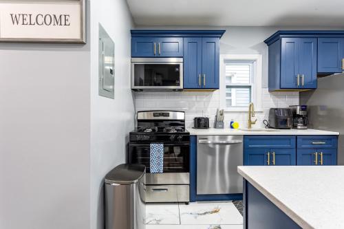 a kitchen with blue cabinets and a stove at Comfort Meets Style 3BR Plus Parking in New Rochelle