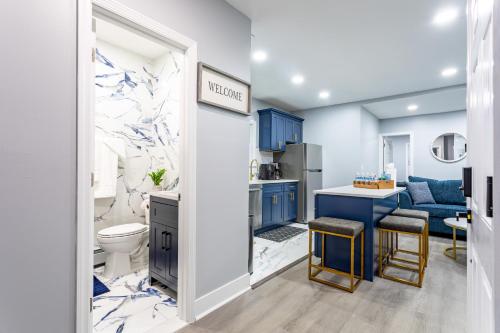 a bathroom with blue cabinets and a kitchen at Comfort Meets Style 3BR Plus Parking in New Rochelle