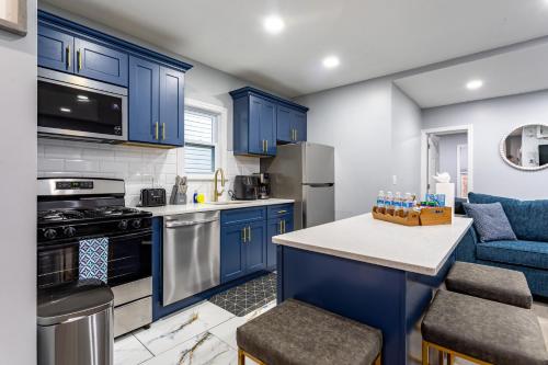 a kitchen with blue cabinets and a blue couch at Comfort Meets Style 3BR Plus Parking in New Rochelle