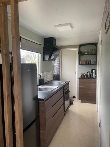 a small kitchen with a sink and a refrigerator at In Daaldersk Plakje in Deinum