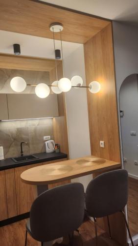 a kitchen with a wooden table and two chairs at Apartmani Dobrinja - Free parking- Rent a car in Sarajevo