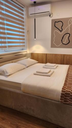 a large bed in a room with a window at Apartmani Dobrinja - Free parking- Rent a car in Sarajevo