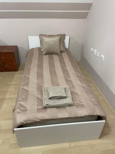a bed with a blanket on it in a room at Central Charm Residence Kumanovo in Kumanovo