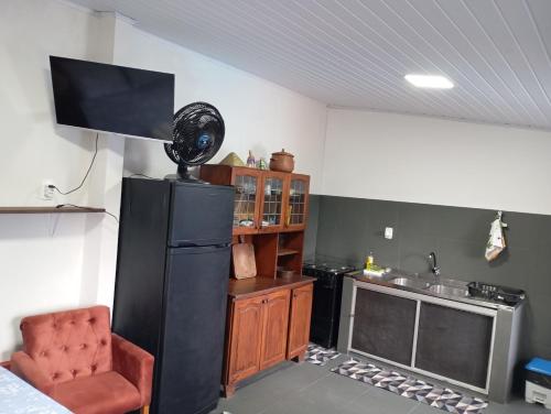 a kitchen with a black refrigerator and a chair at Casa em Penha in Penha