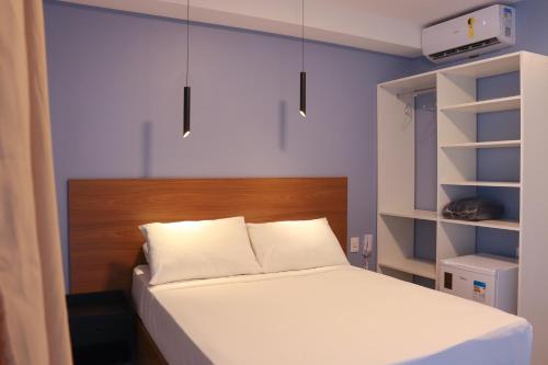 a bedroom with a bed with a wooden headboard at Pousada Barra De Maragogi in Maragogi