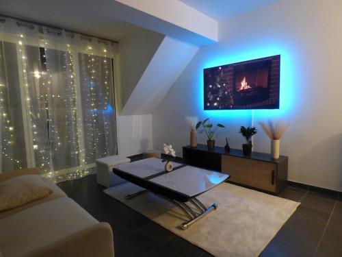 un salon avec un canapé et une télévision au mur dans l'établissement Appartement studio lumineux refait a neuf proche Orly Paris Disneyland, à Limeil-Brévannes