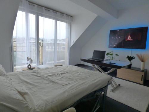 une chambre avec un lit et un bureau avec un ordinateur portable dans l'établissement Appartement studio lumineux refait a neuf proche Orly Paris Disneyland, à Limeil-Brévannes