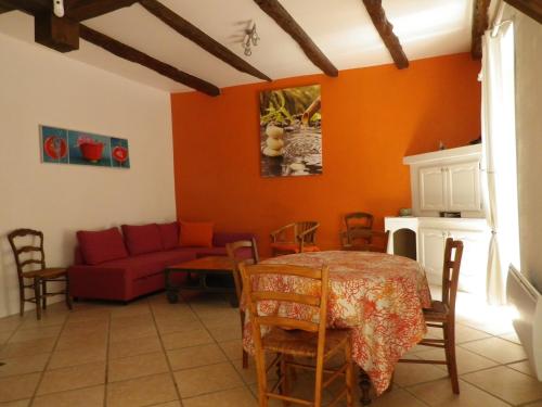 un salon avec un canapé rouge et une table dans l'établissement Mi-fugue Mi-raison, à Saint-Marcel-dʼArdèche