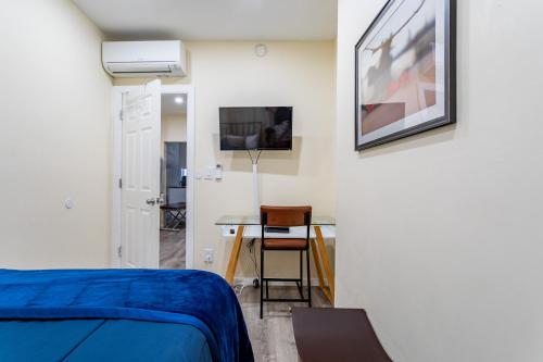 a bedroom with a bed and a table and a tv at Upscale Relax 2 Bedroom near Yankee Stadium 14 min drive in New Rochelle