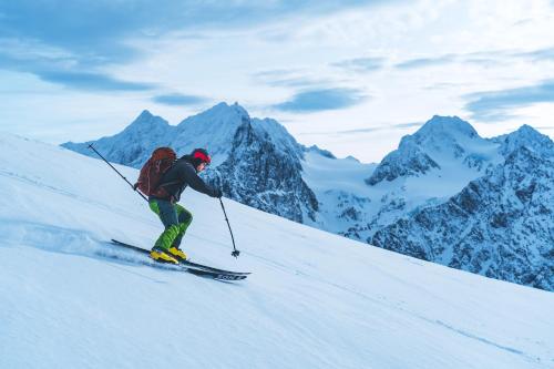 a man is skiing down a snow covered mountain at Traditional Arctic Farmhouse in Sørlenangen