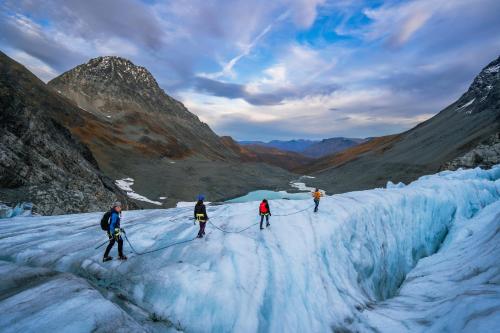 a group of three people walking on a glacier at Traditional Arctic Farmhouse in Sørlenangen