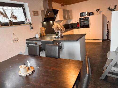 a kitchen with a wooden table and a counter top at Ferienwohnung beim Pferdehof in Neuenstein