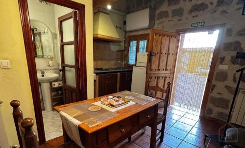 a kitchen with a wooden table and a sink at El Rincón de la Avena in El Barraco