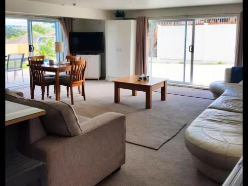 a living room with a couch and a table at Modern and spacious 1-Bedroom Holiday Home in Whangarei