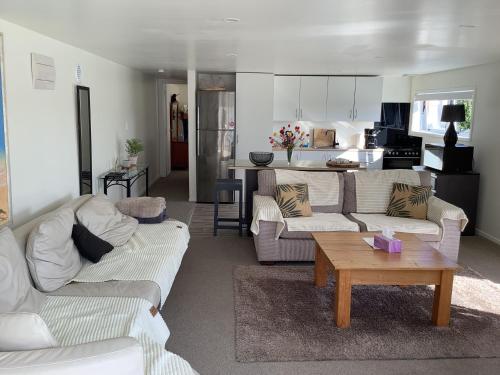a living room with two couches and a coffee table at Modern and spacious 1-Bedroom Holiday Home in Whangarei