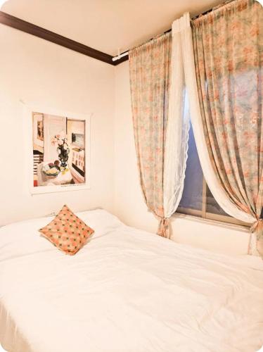 a bedroom with a white bed and a window at Comma in Daegu