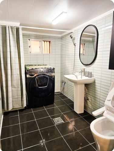 a bathroom with a washing machine and a sink at Comma in Daegu