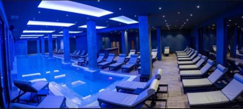 a swimming pool with lounge chairs in a building at Apartman Magdalena Kopaonik in Cajetina