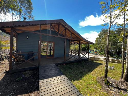 a tiny house with a porch and a deck at Panigal in Hornopiren